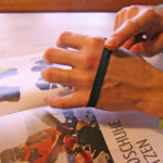 Una mano avvolge intorno all'altra un nastro qualunque per misurarne la circonferenza