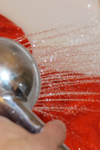 Il pomo di una doccia sciacqua il sacco a pelo