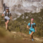 Due runner corrono su un sentiero in montagna
