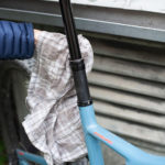 un uomo pulisce il tubo sella con un panno