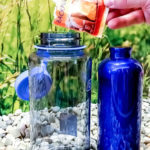 il lievito in polvere viene versato in una borraccia come mezzo alternativo alla pastiglia per la pulizia