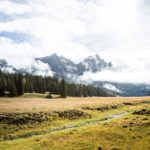 Una radura d'alta montagna e un massiccio montuoso sullo sfondo