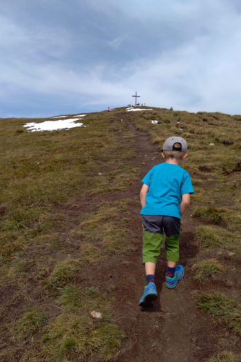 Un bambino cammina verso la vetta di una gita