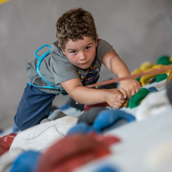 Un bambino arrampicata in palestra di arrampicata