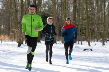 tre persone corrono sulla neve