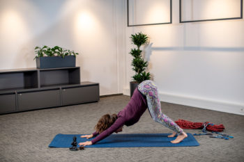 Posizione del cane a testa in giù con le ginocchia piegate