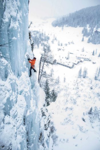 Un grande cascata di ghiaccio con un climber che sta arrampicando