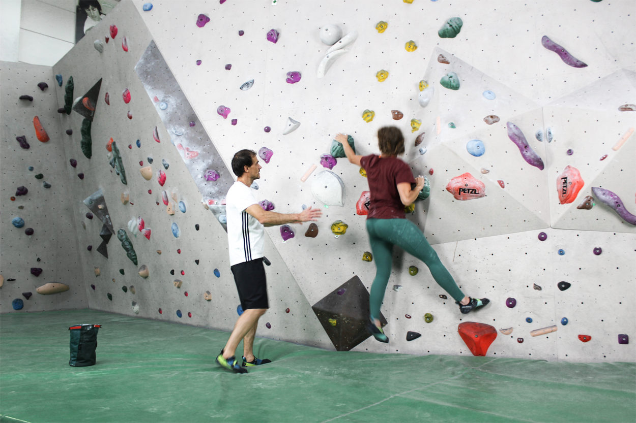 Una climber si allena in sala boulder