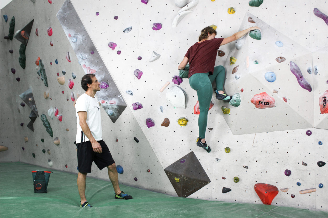 Una climber si allena in sala boulder