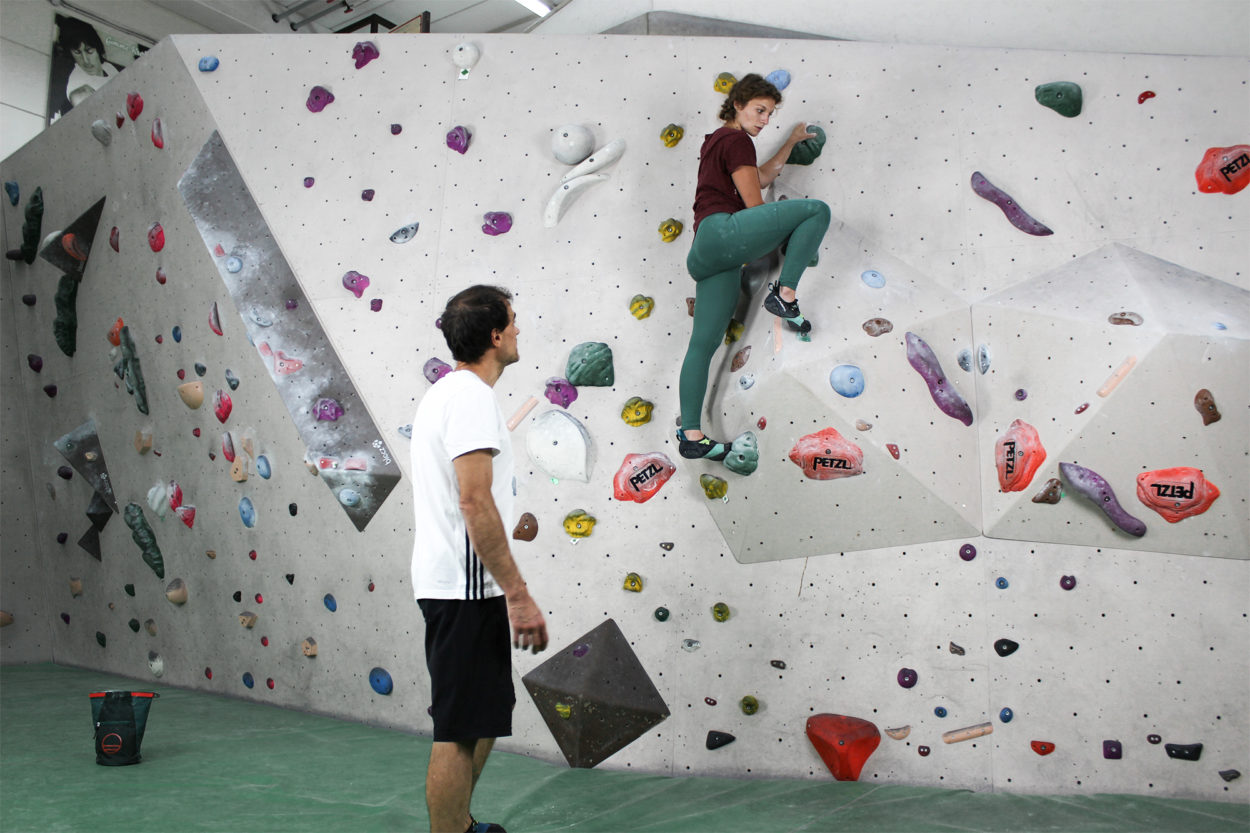 Una climber si allena in sala boulder