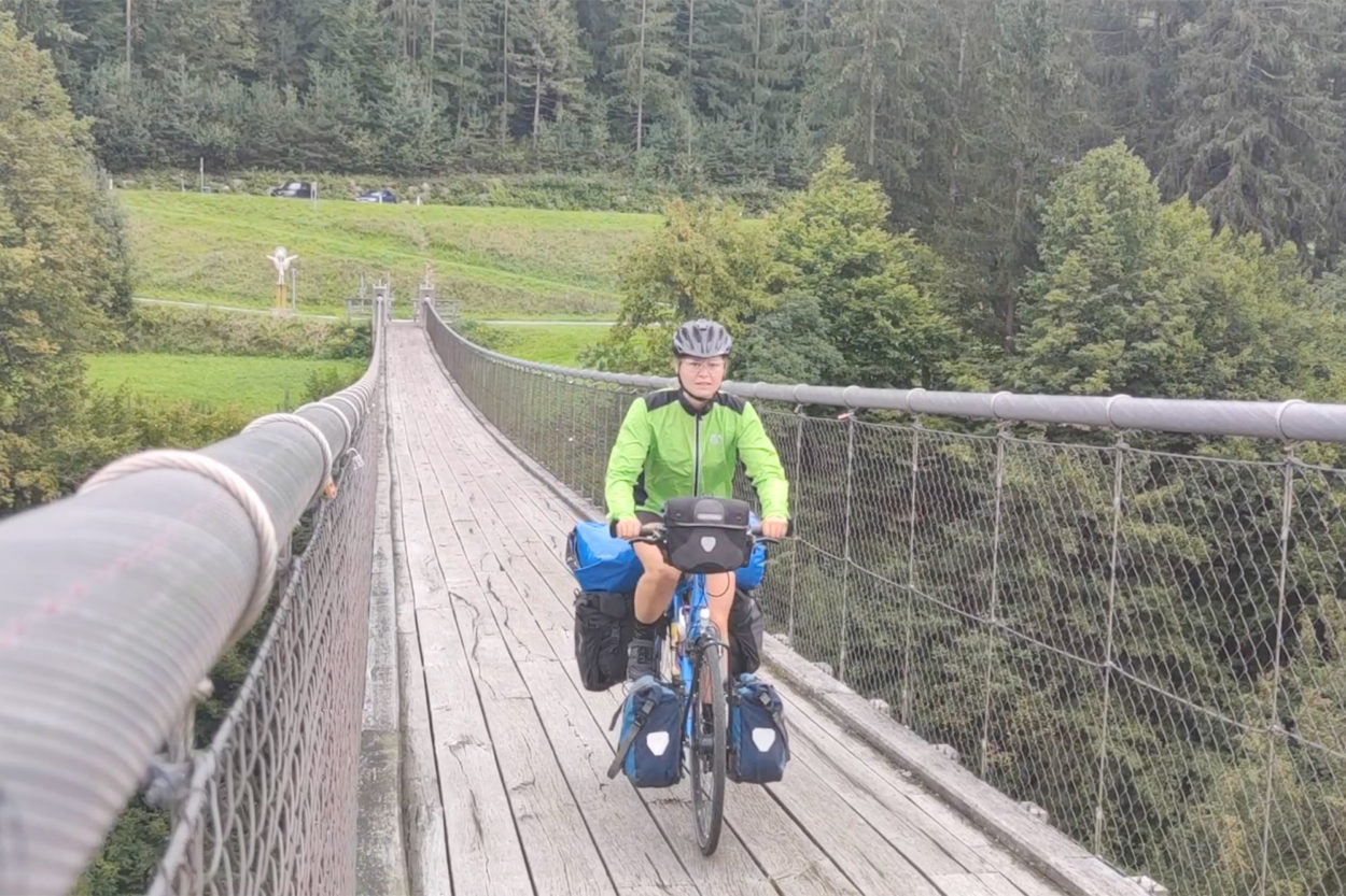 maddi attraversa un ponte con la sua bici