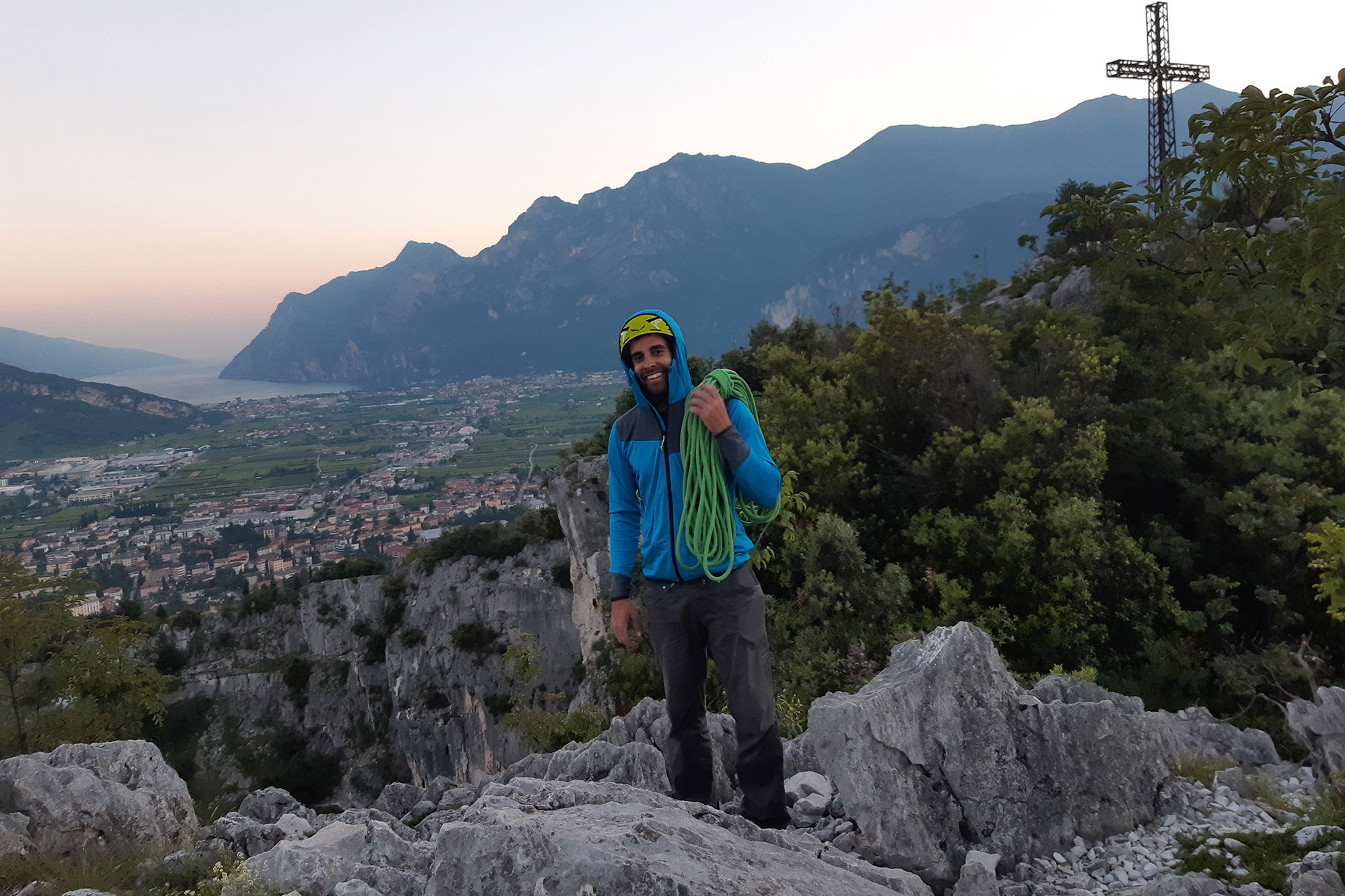 Stefano Ragazzo in cima al Colodri, con le ultime luci su Arco e il Lago di Garda